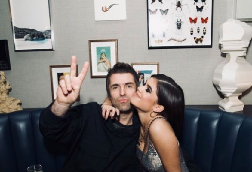 Liam Gallagher flashing a peace sign while sitting on a sofa with daughter Molly Morrish-Gallagher