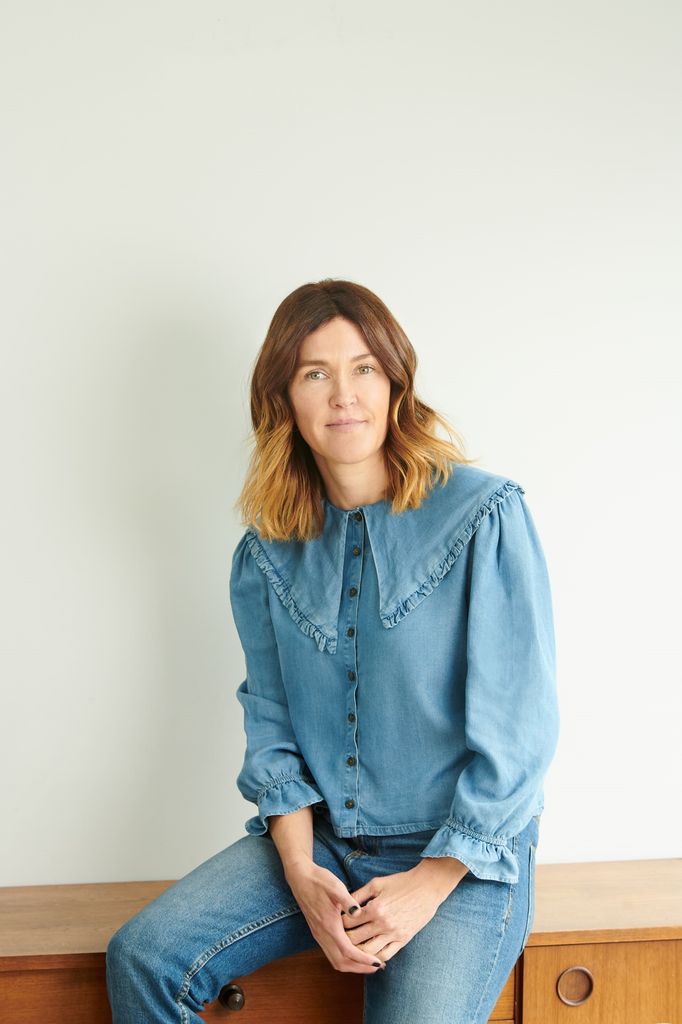 women in denim shirt and jeans smiling for the camera