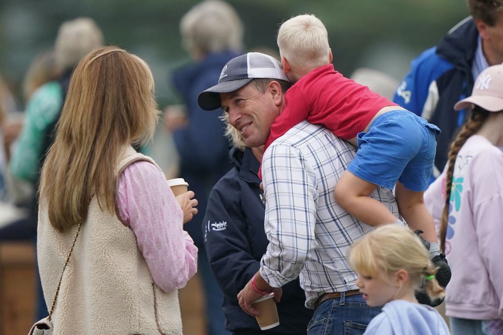 Lucas Tindall climbs on the back of his uncle, Peter Phillips