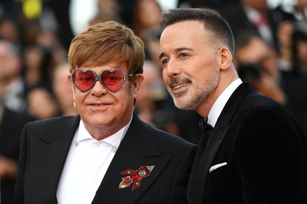 Elton John in heart sunglasses with David Furnish