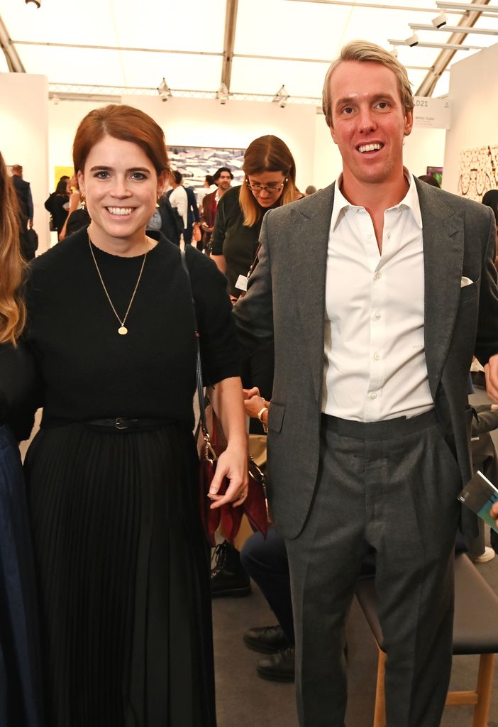 Princess Eugenie in black sweater and skirt and Michael Walker posed at gallery
