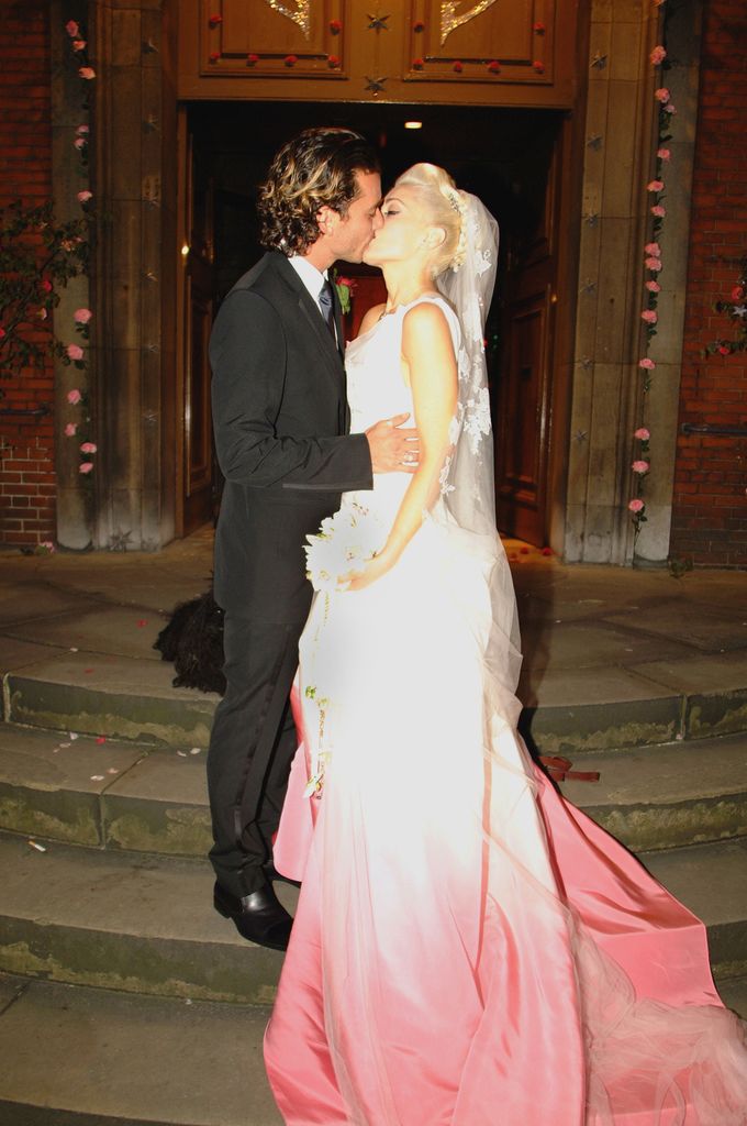 Gavin Rossdale kissing Gwen Stefani in pink and white wedding dress