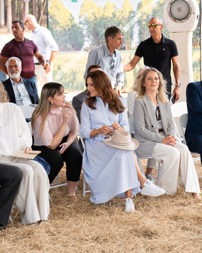 Mary sitting talking to woman in shirt dress