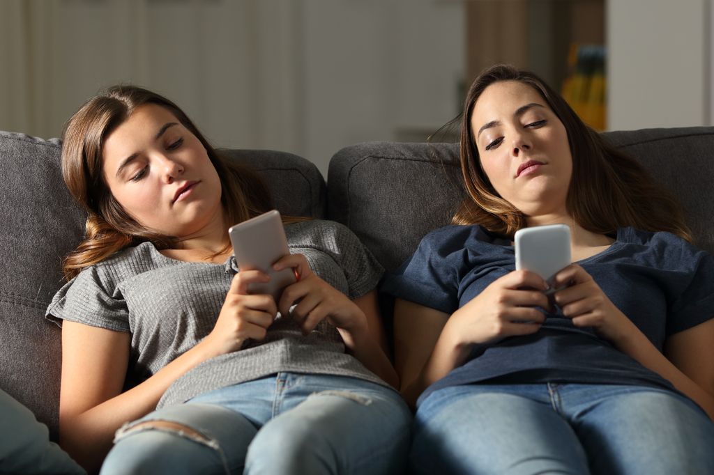 Bored friends using their smart phones