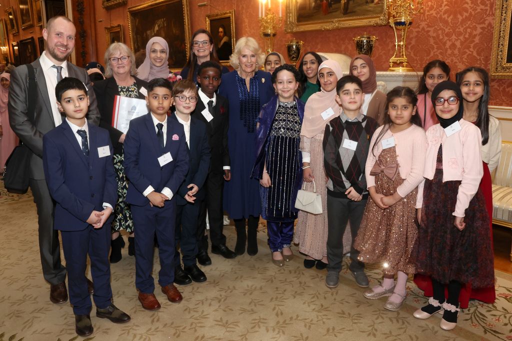 Britain's Queen Camilla (C) poses with children during a reception for the BBC's 500 Words Finalists at Buckingham Palac