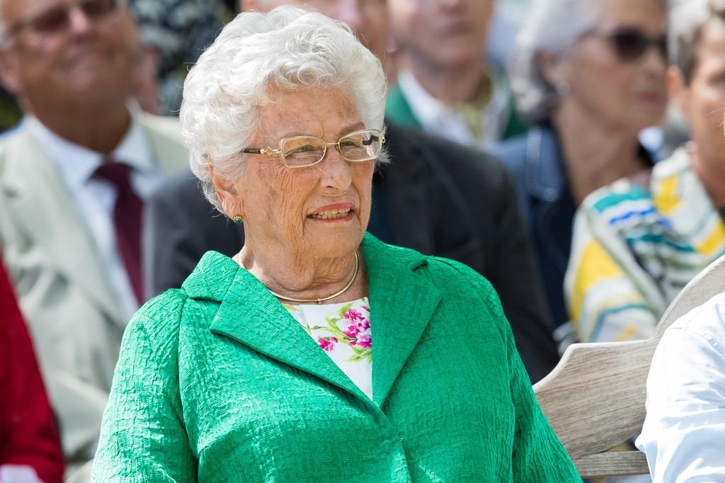 Princess Astrid sitting at a service in a green coat