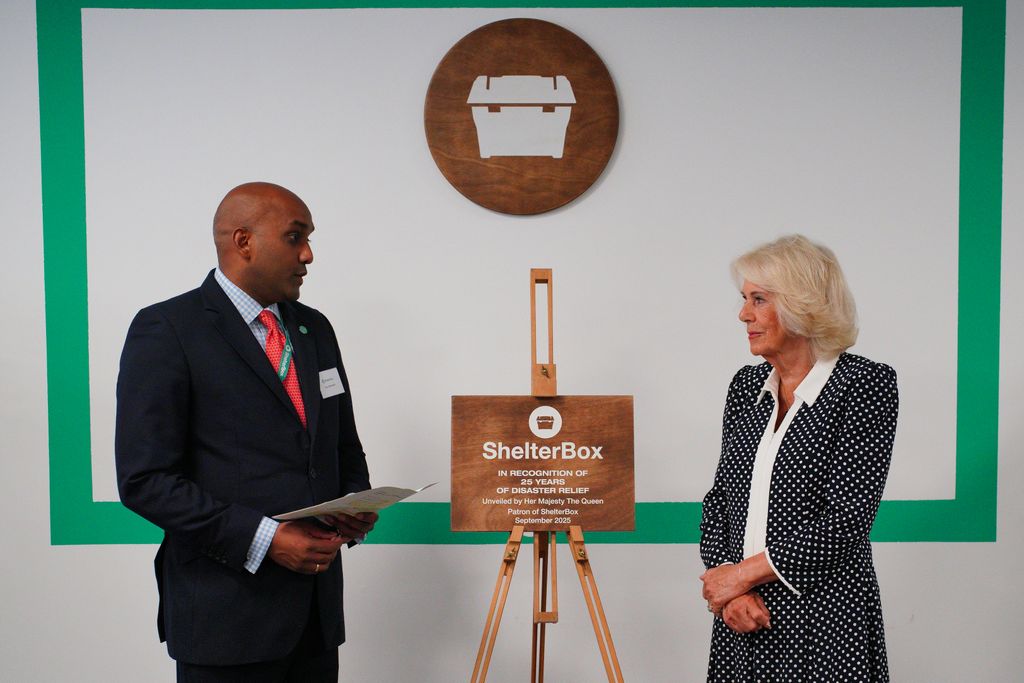 man and woman standing in front of wooden sign