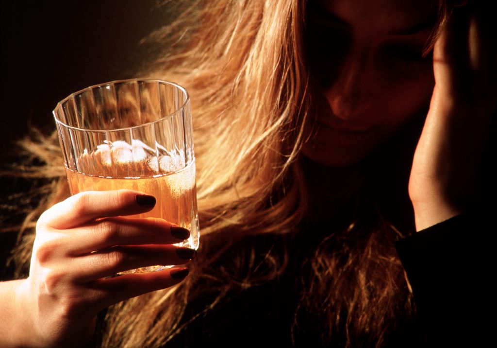 woman holding glass of alcohol