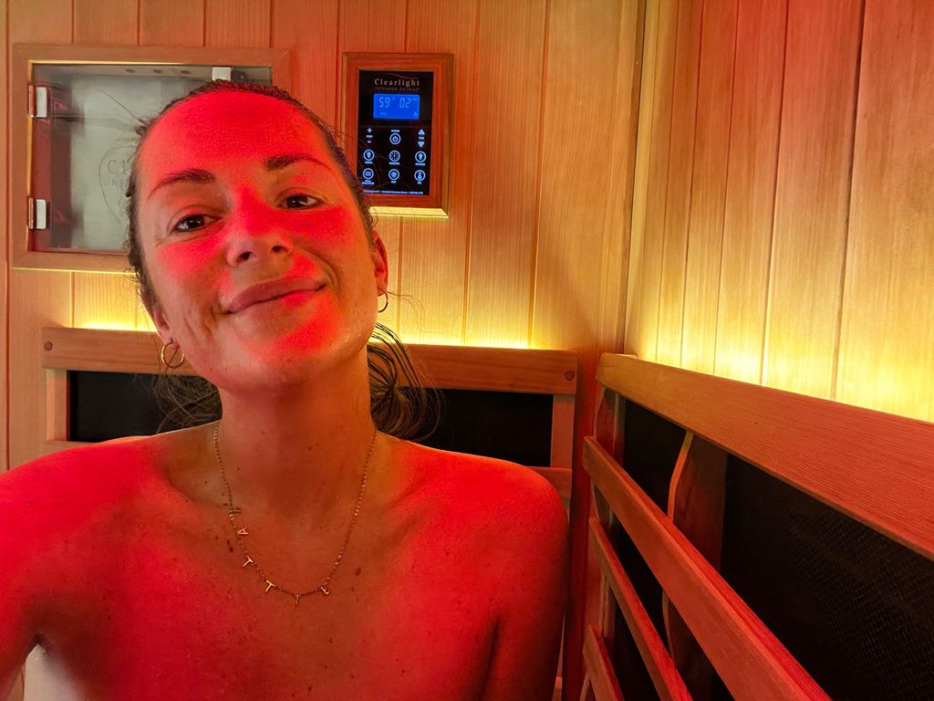Young woman smiling in an infrared sauna
