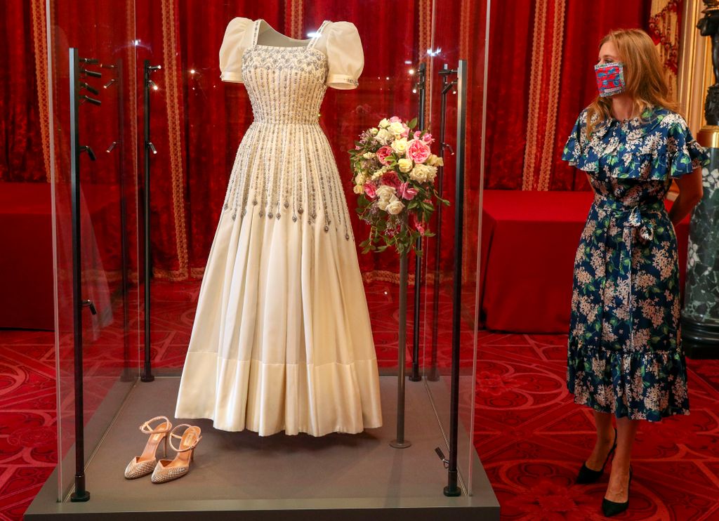 Princess Beatrice posing alongside her wedding dress as it goes on display at Windsor Castle