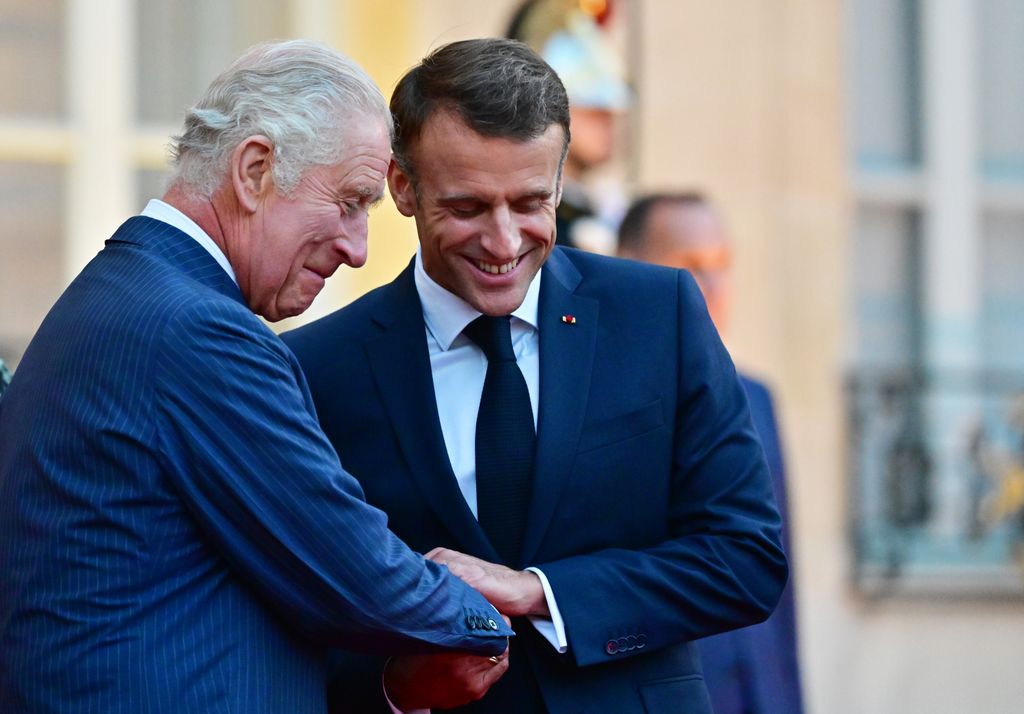 King Charles laughing with Emmanuel Macron
