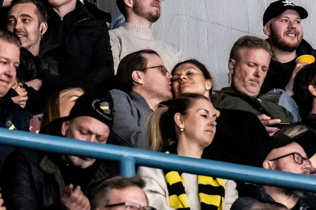 couple sharing kiss at hockey game
