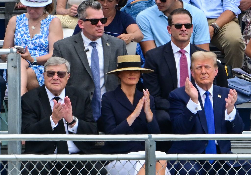 Former US President Donald Trump (R), with former First Lady Melania Trump (C) and her father Viktor Knavs (L), attends the graduation ceremony of his son, Barron Trump