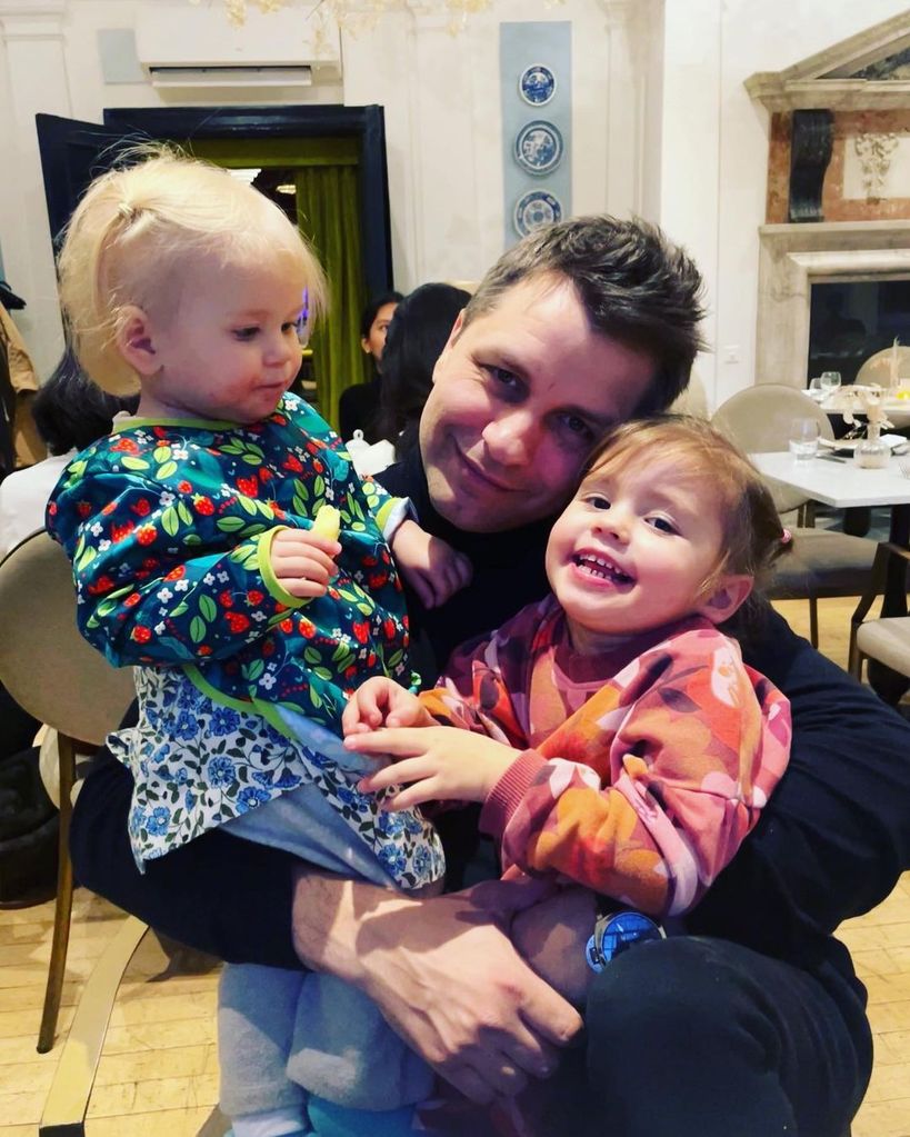 Pasha Kovalev holding his two daughters Maven and Noa