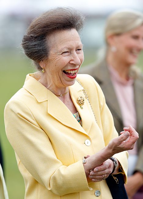 princess anne in yellow blazer laughing during day at races