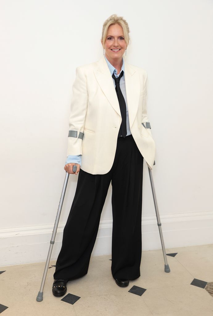Penny Lancaster on crutches in a suit