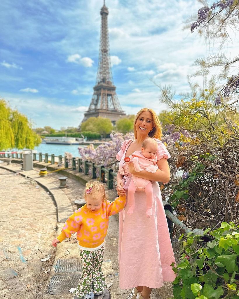 stacey solomon wearing pink dress holding baby daughter belle and daughter rose posing in paris
