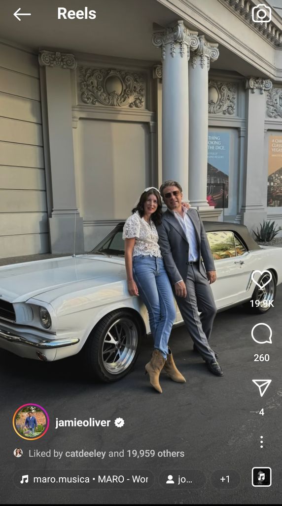 couple leaning against vintage white car