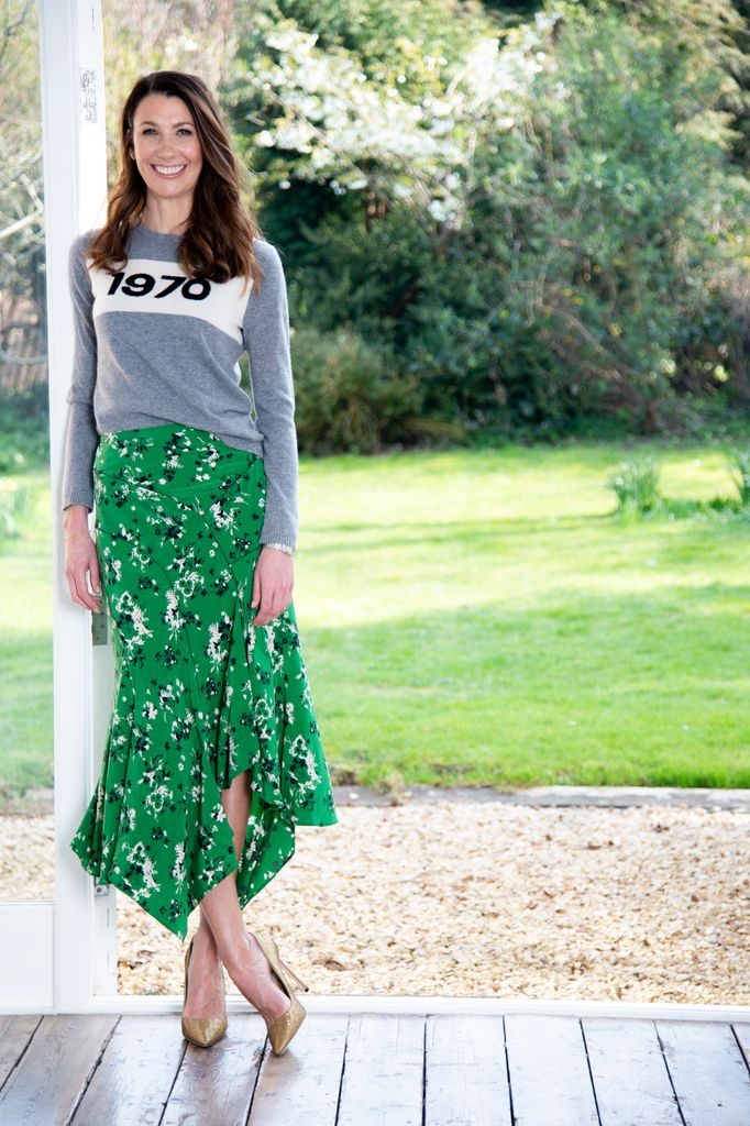 Rosie Green journalist posing on porch wearing green floral skirt