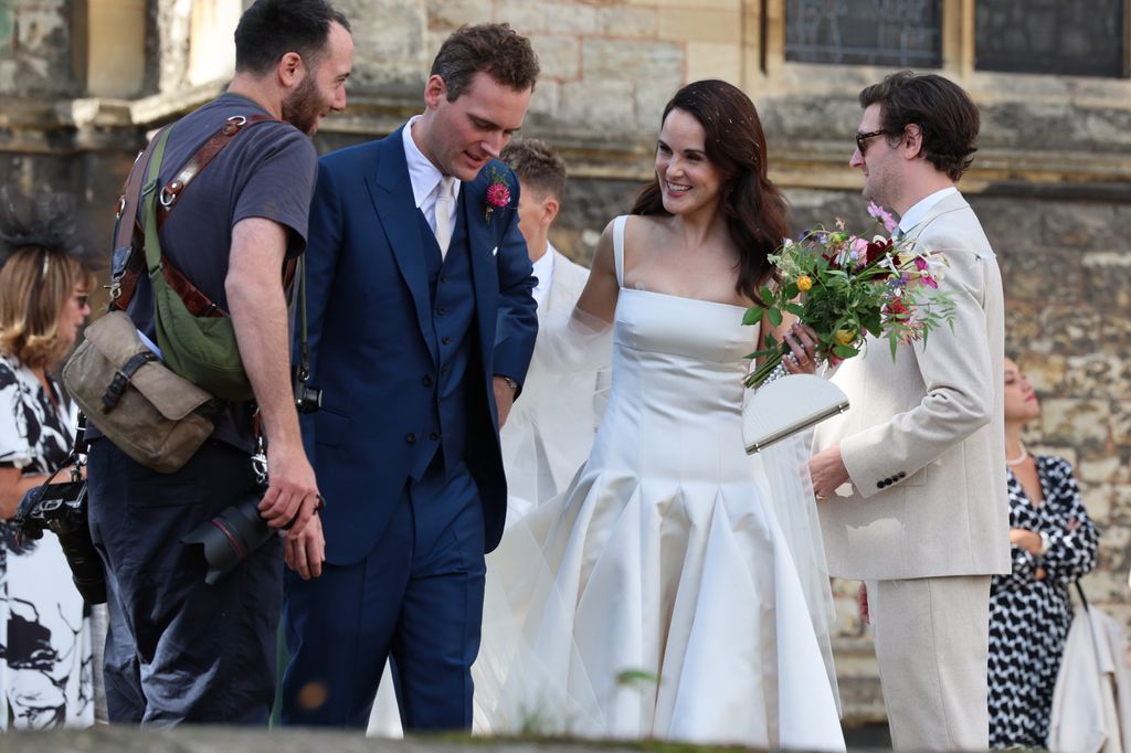 Michelle's elegant white satin Emilia Wickstead gown was complemented by an Aspinal of London Florence bag