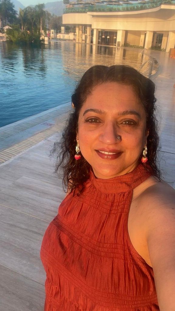 woman taking a selfie in a rust coloured halterneck top