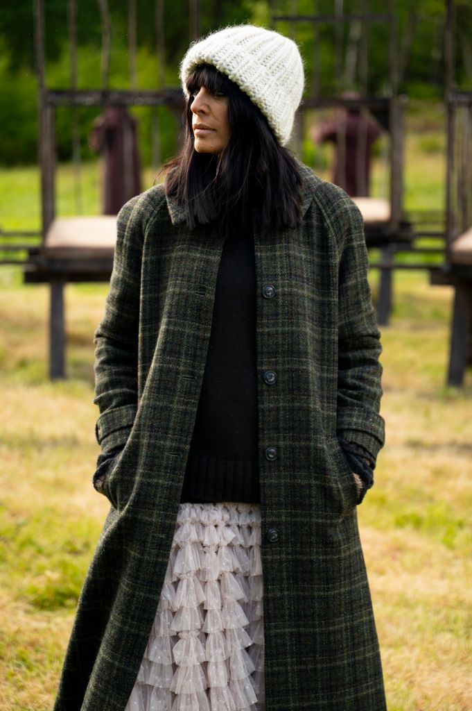 Claudia Winkleman green check coat and white frill skirt and white beanie hat on the traitors