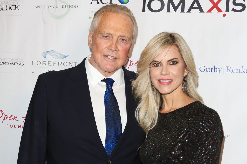 Lee and Faith Majors posing together and smiling on a red carpet 