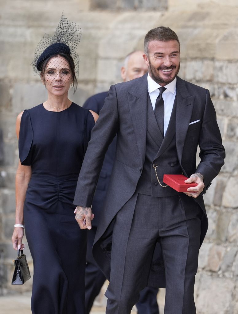 Former England footballer David Beckham (R) comes out into the yard followed by his wife singer and fashion designer Victoria Beckham
