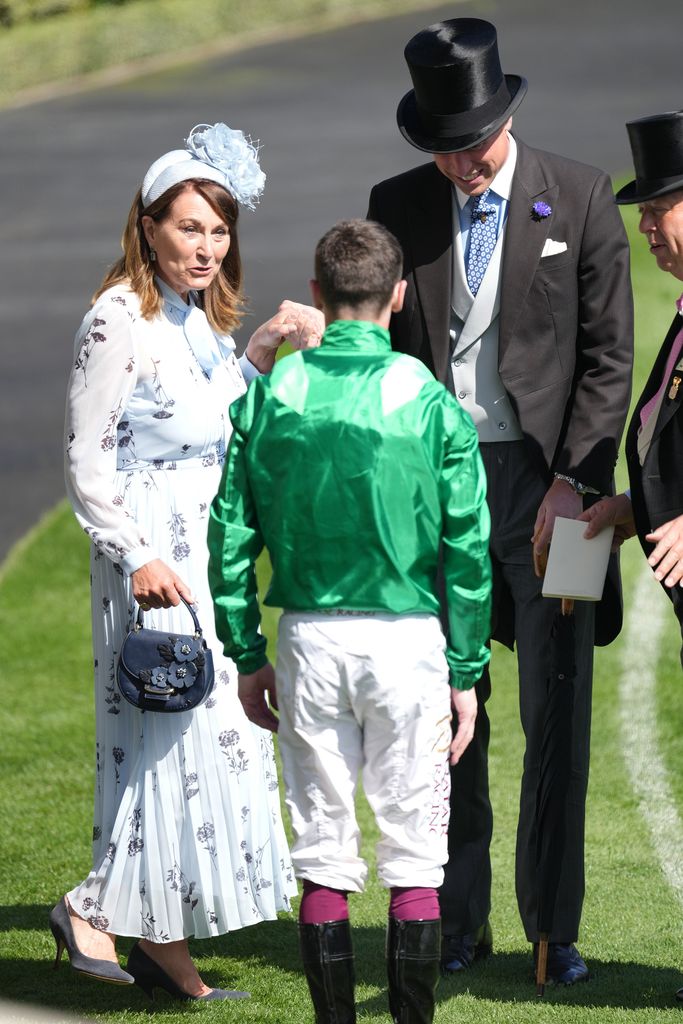 Prince William gives Carole Middleton a helping hand after she gets her heel caught in the grass