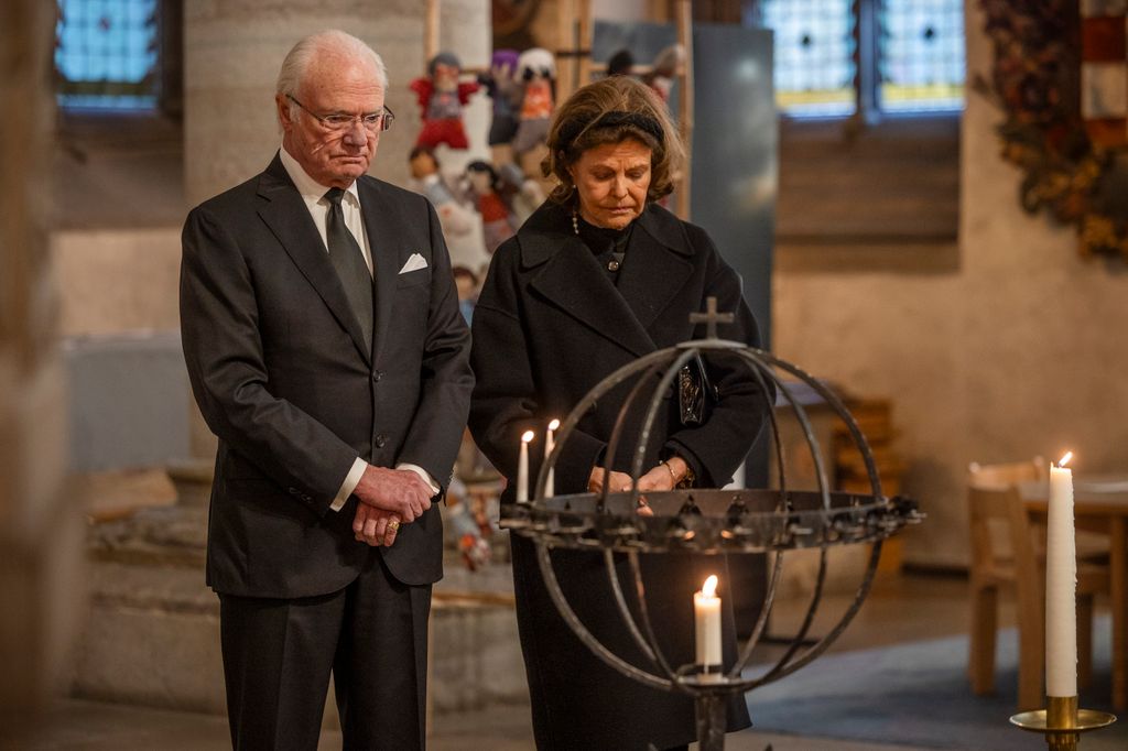 King Carl XVI Gustaf and Queen Silvia light candles inside St Nicolai Church to honour the victims of the school shooting on February 5, 2025 in Orebro, Sweden