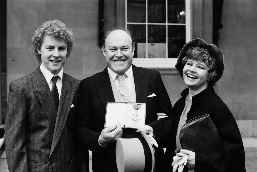 English actor Timothy West, holding his CBE, with his wife Prunella Scales and their son, British actor Samuel West, London, UK, 4th December 1984