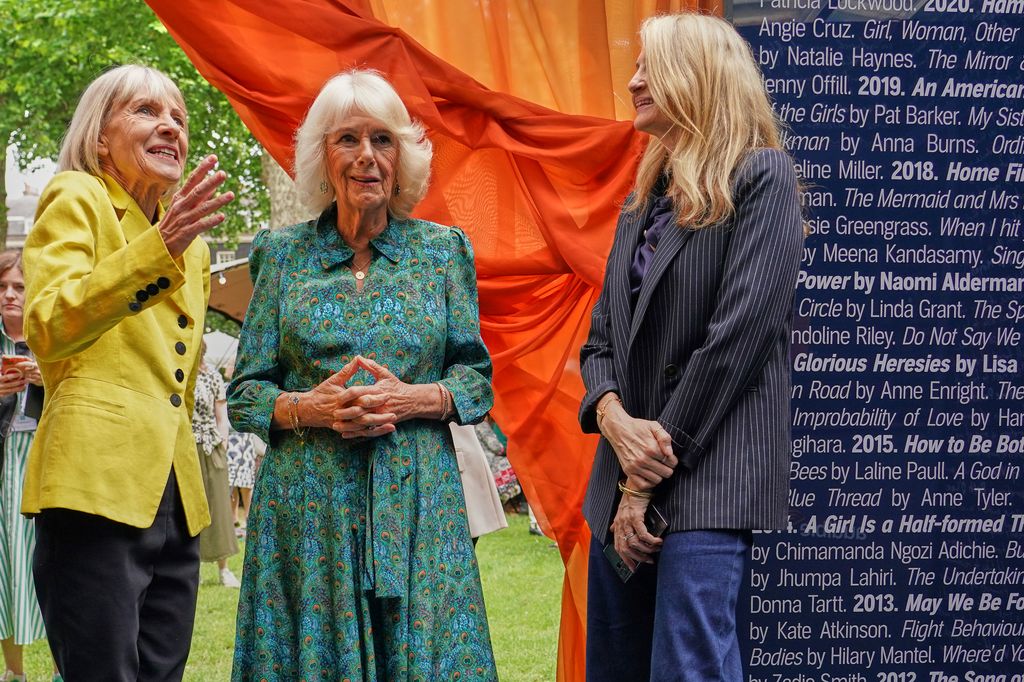 Queen Camilla and another woman listening to Kate Mosse