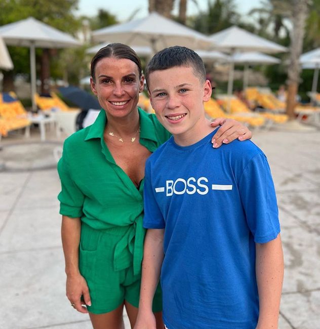coleen rooney in green playsuit with arm around son kai 