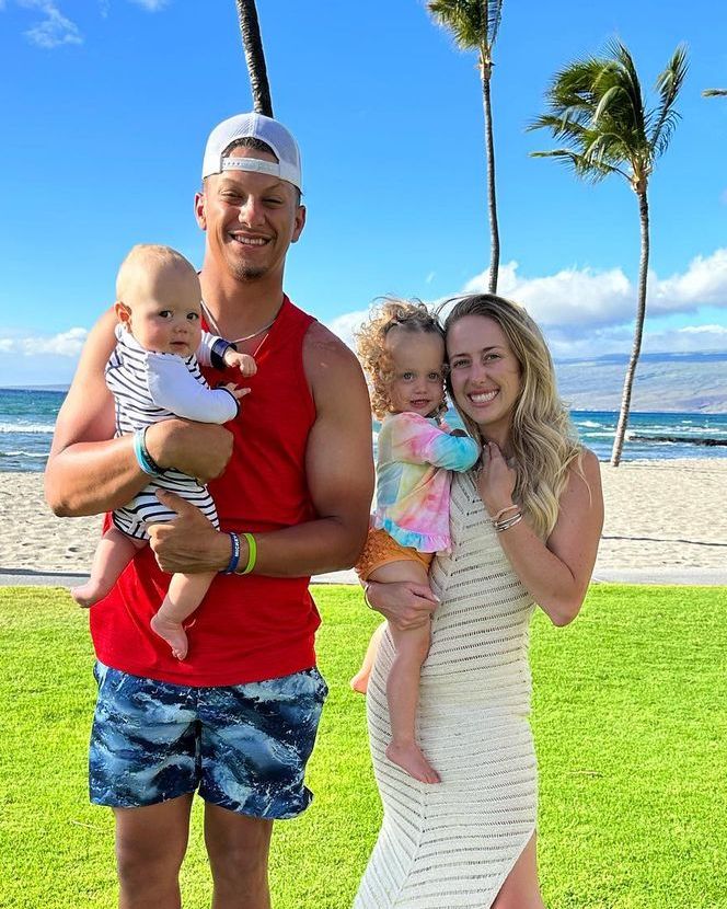 Patrick and Brittany Mahomes stand with their children on the beach