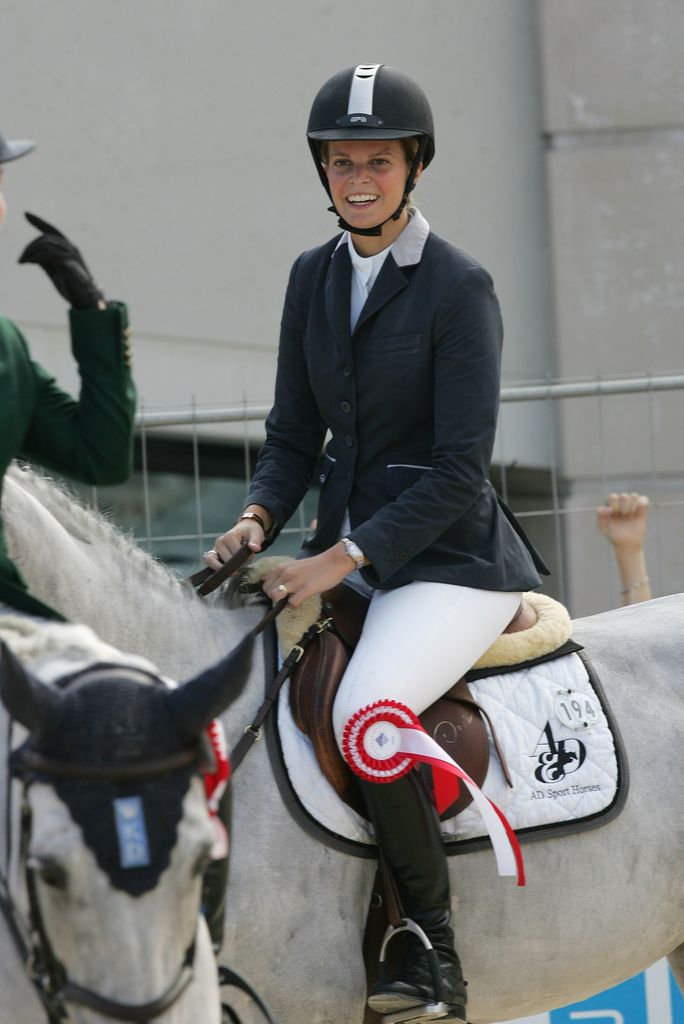 Athina Onassis riding a horse in a competition