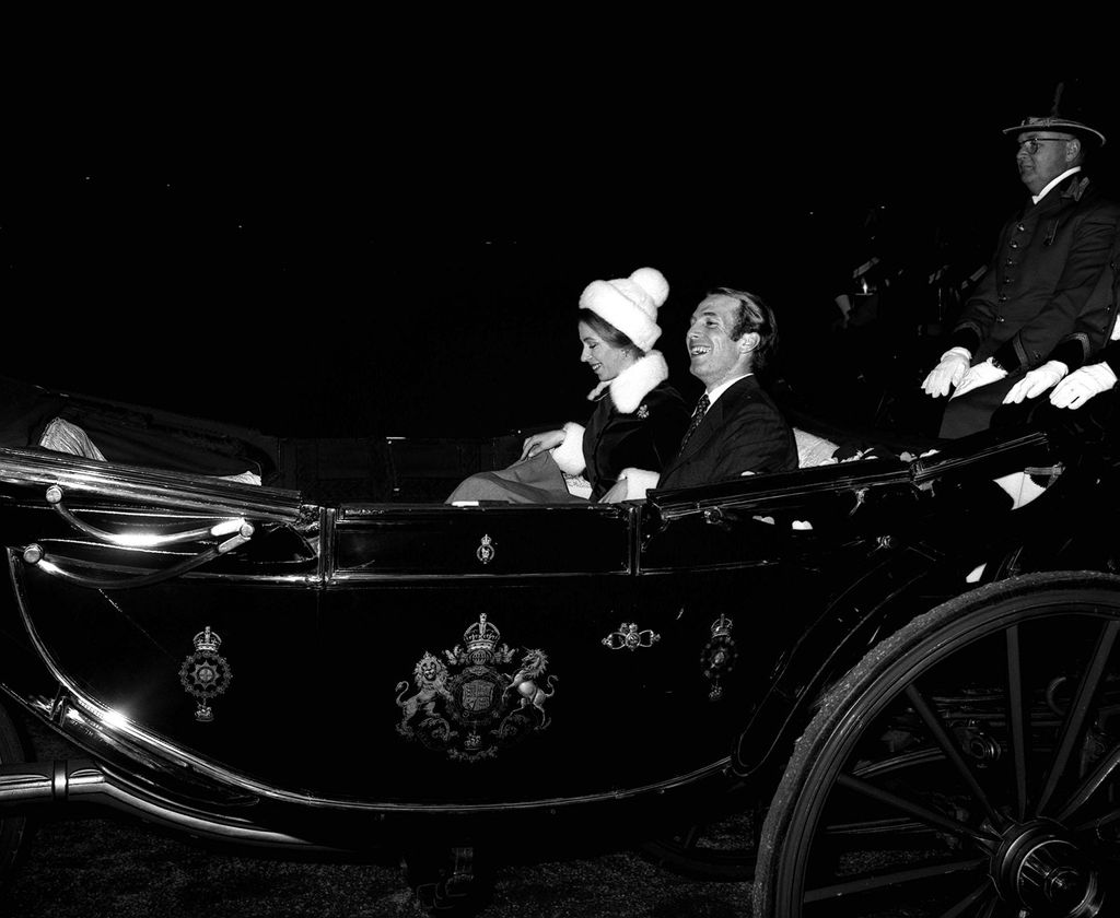 Princess Anne in a bobble hat and a fur coat in a carriage with Mark Phillips