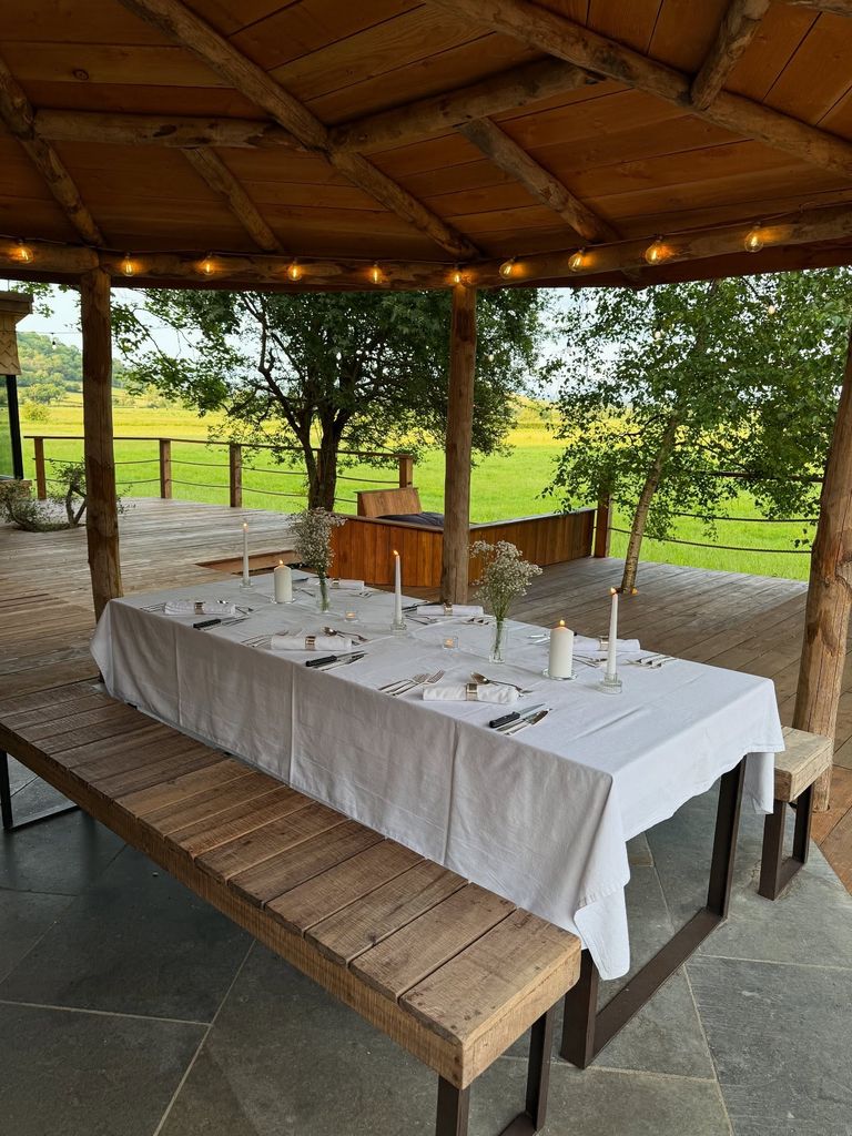 outdoor table set for dinner with candles and flowers 