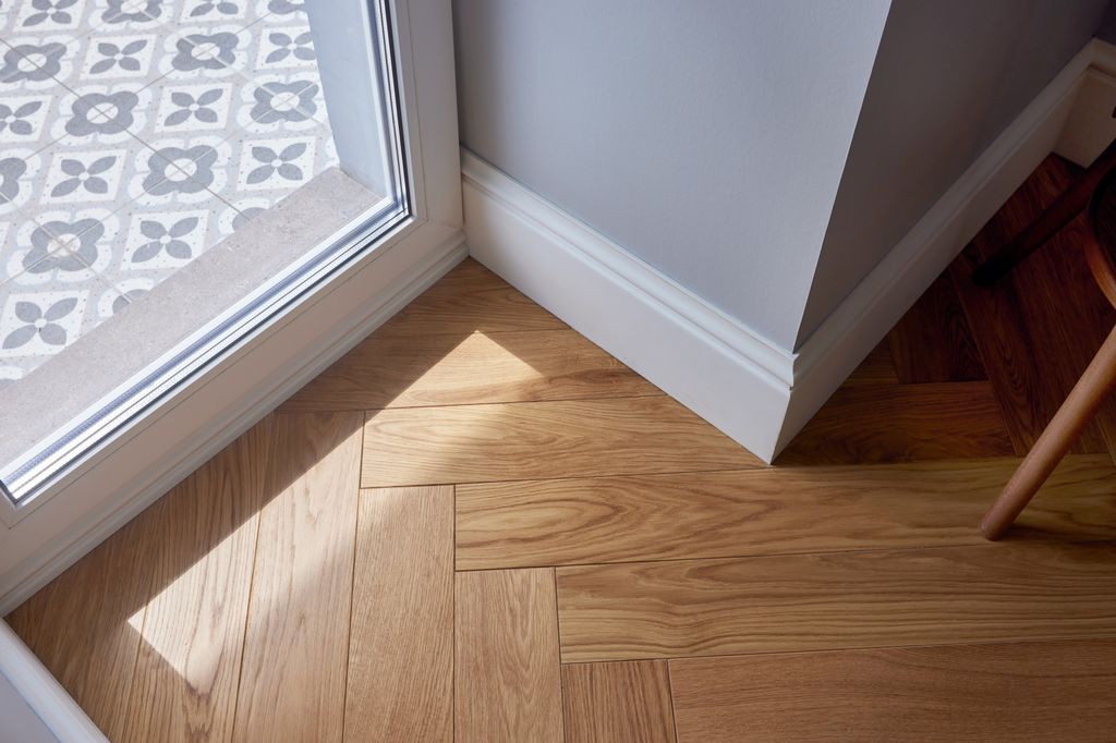 The bright corner features hardwood floor and a patterned tile entryway that create an inviting and stylish atmosphere