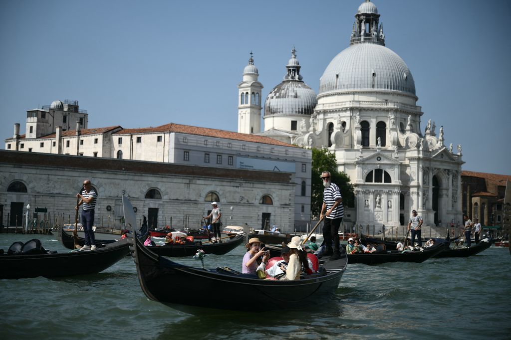 Tourists enjoy a gondola ride on the Grand Canal in Venice lagoon on June 25, 2026