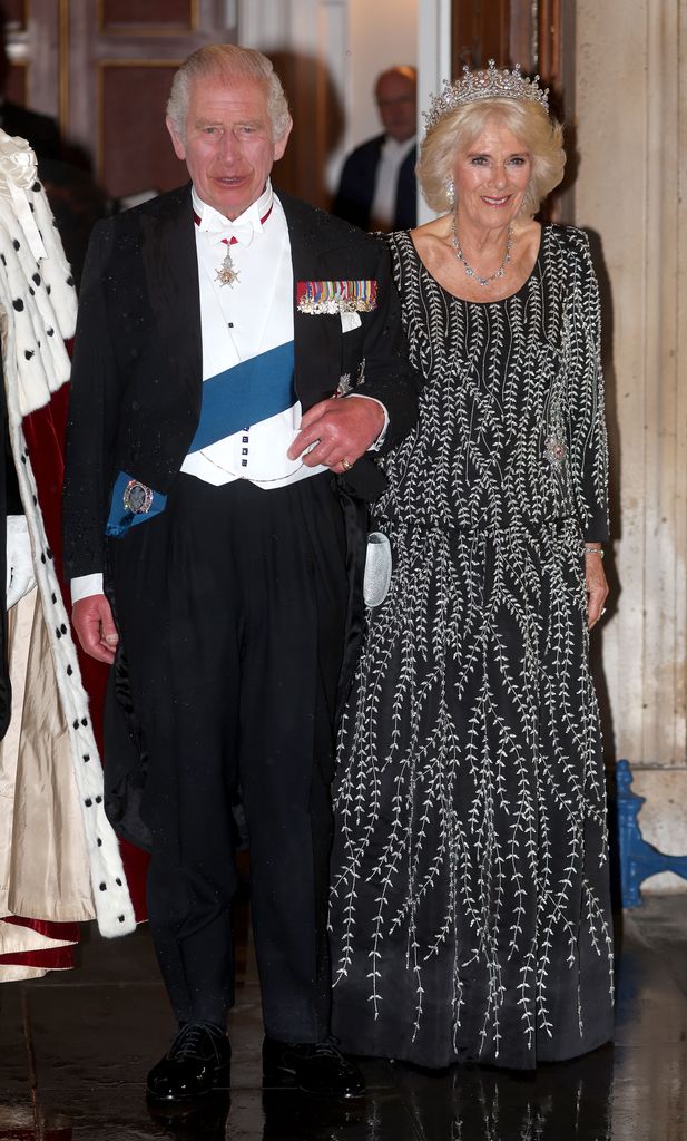 King Charles in tuxedo and Queen Camilla wearing a gown and tiara at Mansion House