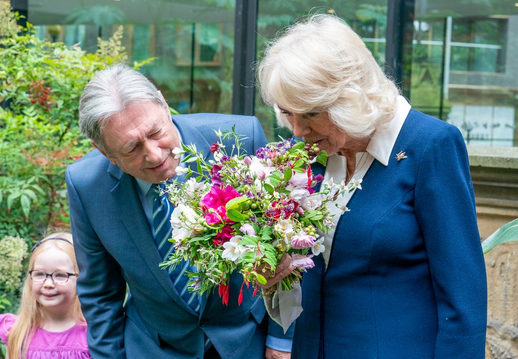 Queen Camilla sniffs flowers