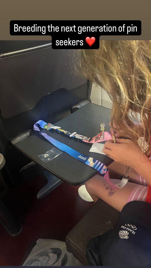 young girl adding pin to landyard on train 