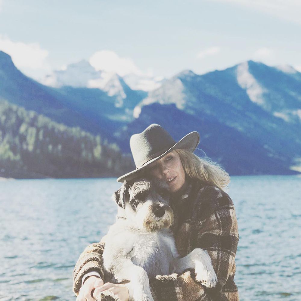 Kelly Reilly with her dog. Mountains in the background.