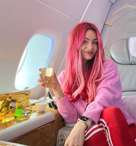 Dianne Buswell holding a glass while sat on an aeroplane