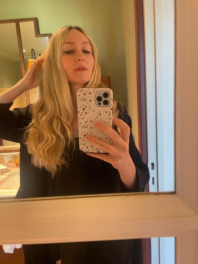woman taking a mirror selfie with long blonde hair 