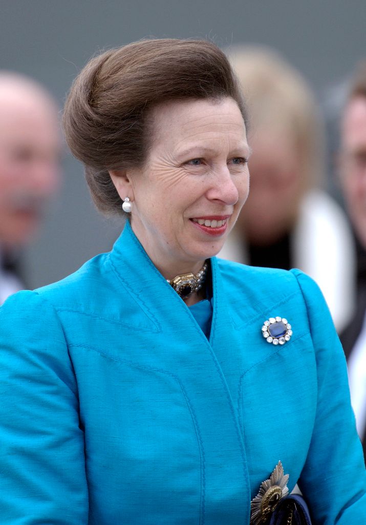 Princess Anne in blue jacket with dark hair up