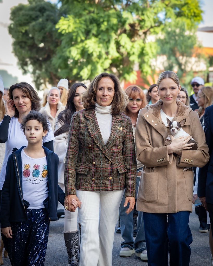 Charlene holding dog in coat leading dog walk