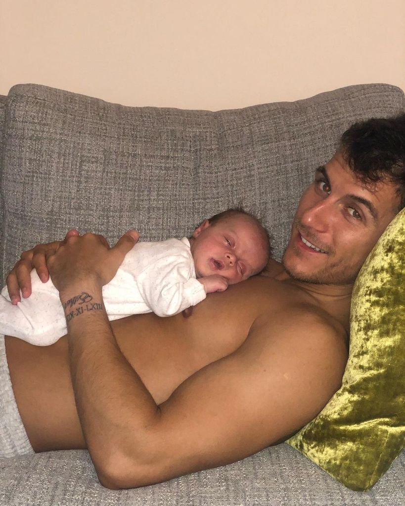 shirtless gorka marquez lying on sofa cradling baby daughter mia 