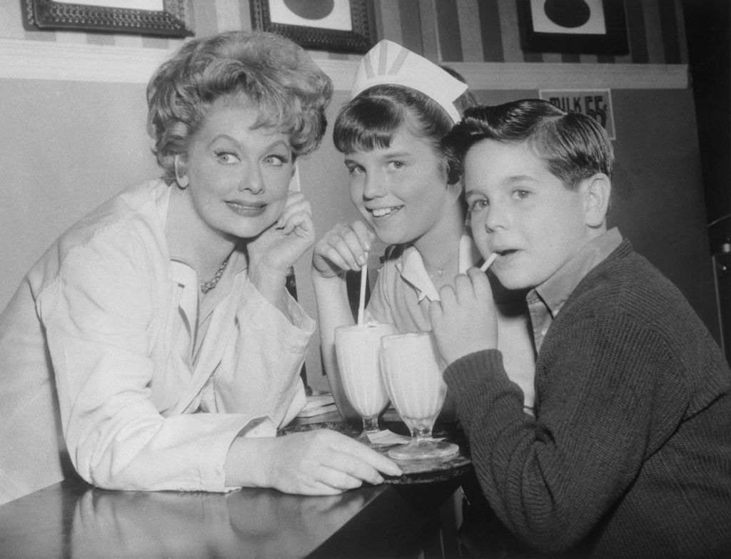 Comedienne Lucille Ball takes a break on a Hollywood TV film set to play hostess to her own youngsters at a movie "soda fountain." Daughter Lucie Arnaz was making her acting debut with her mother in the Lucy Show to be shown on the CBS-TV network on March 4th. Son Desi Arnaz Jr., was just visiting this time.