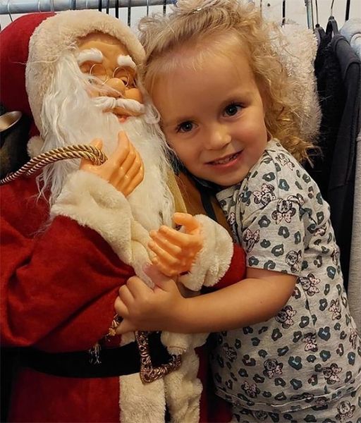 Mia hugging a figure of Father Christmas